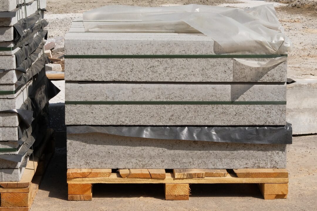 Construction Materials. Pile of gray bricks and slabs at construction site. Building materials for construction of buildings and structures.